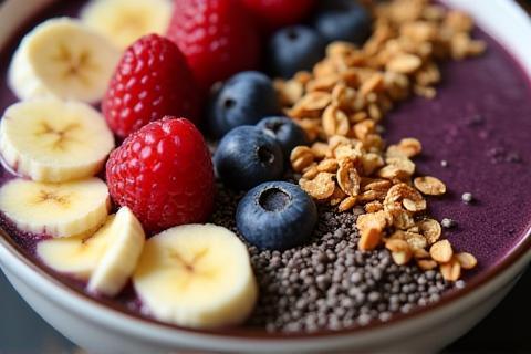 Close up of a beautifully arranged acai bowl with granola, fruit, and seeds.